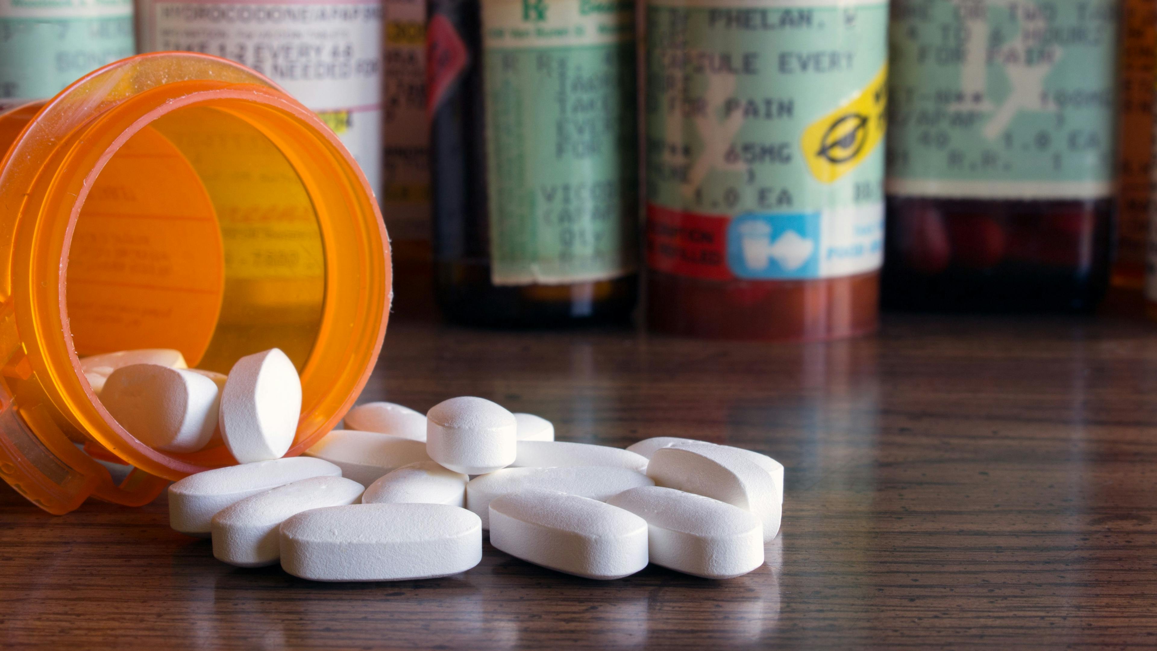 Prescription opioids with many bottles of pills in the background. | Kimberly Boyles - stock.adobe.com